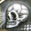 Adrian Reynolds' acrylic painting on a wooden panel, Rust in P-East, shows a close-up detail of an airbrushed skull.